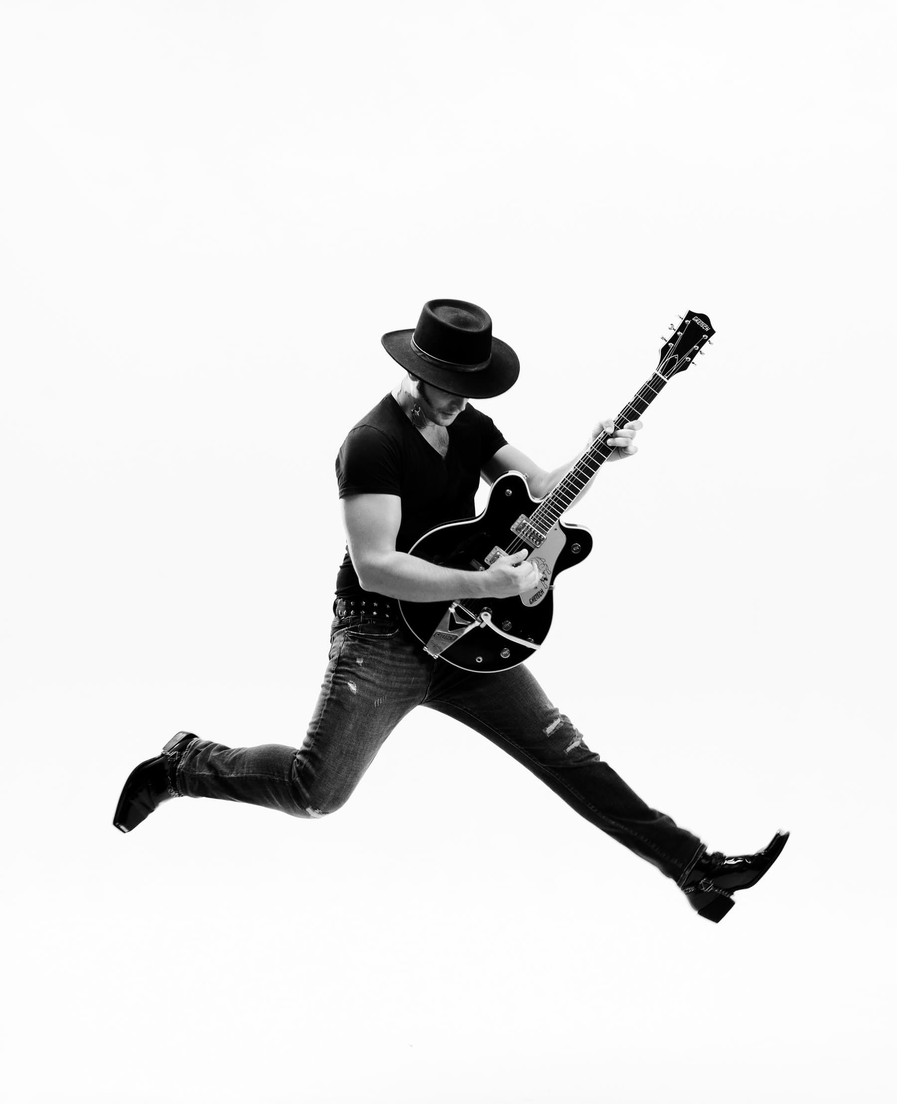 GRAUX leaping mid-air with a Gretsch guitar, studio portrait