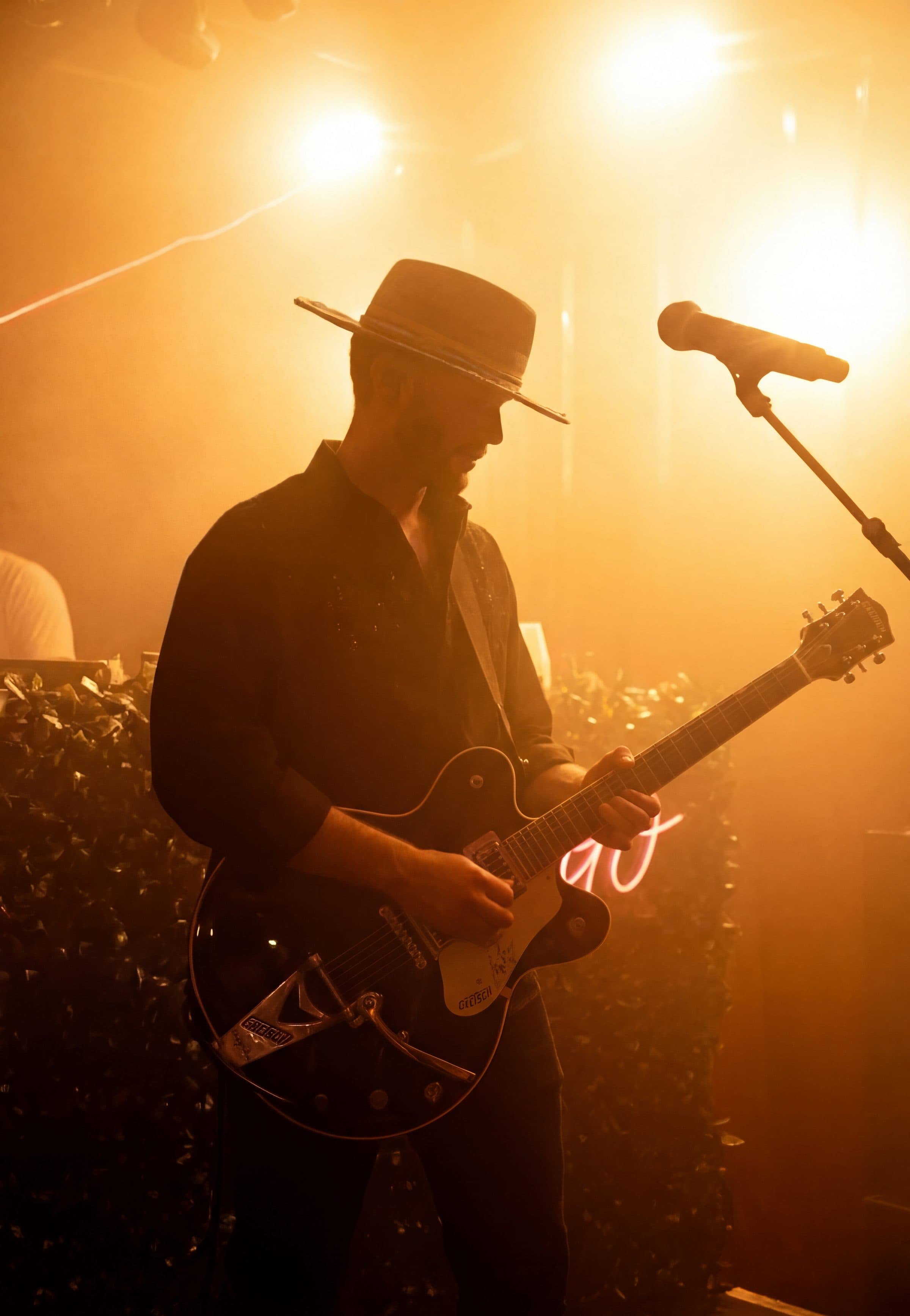 GRAUX performing live, playing guitar under stage light
