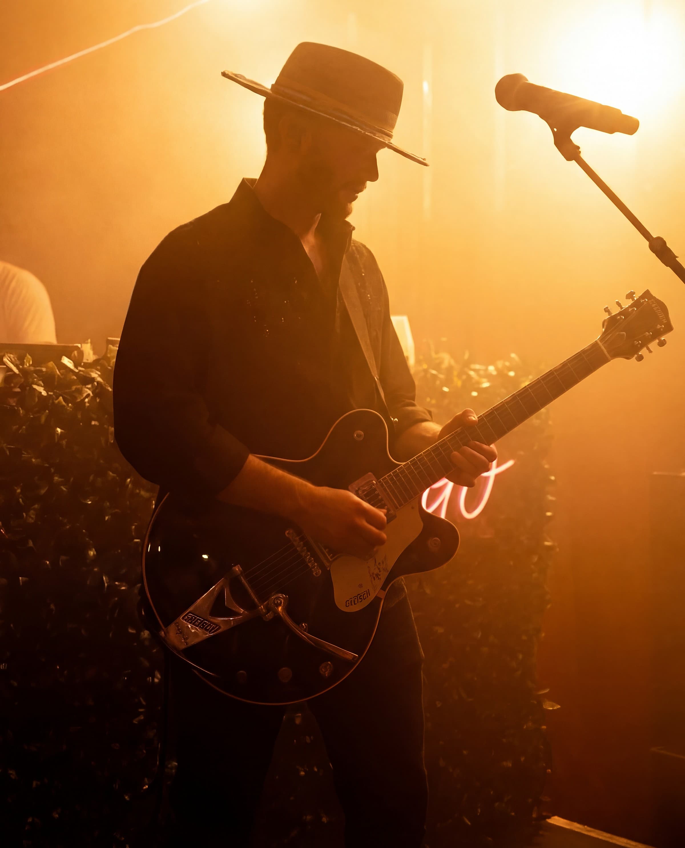 GRAUX performing live, playing guitar under stage light