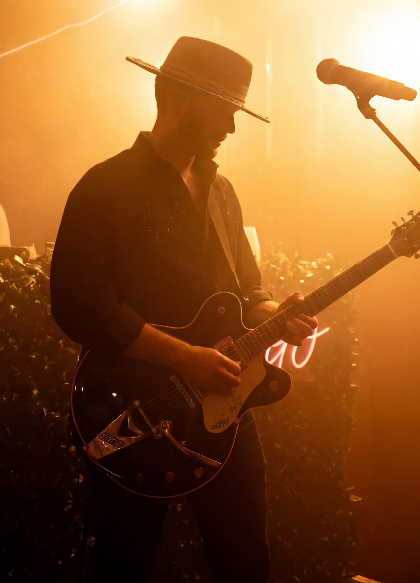 GRAUX performing live, playing guitar under stage light